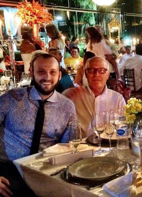 Gui Parras adulto ao lado do avô em um evento, simbolizando a continuidade de uma história iniciada na infância.
